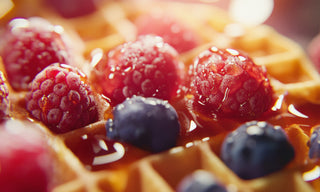 raspberry and blueberries on a waffle and syrup