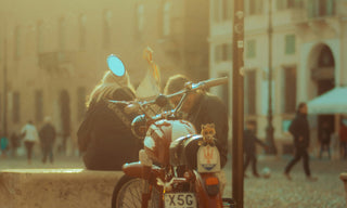 sunlit italian city with a couple and a motorcycle