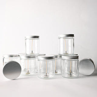 Clear glass jars with metal lids on a white background