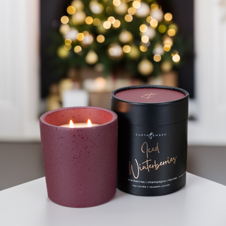 the flecked dark burgundy lit candle and its tube 