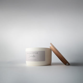 the cream ceramic statement jar with the wood lid leaning against it 