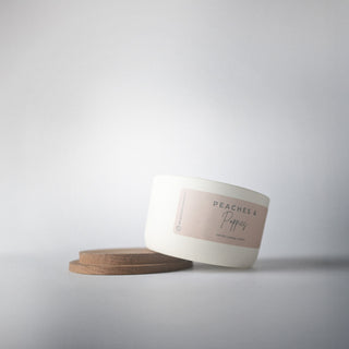cream ceramic statement jar resting on its wood lid 