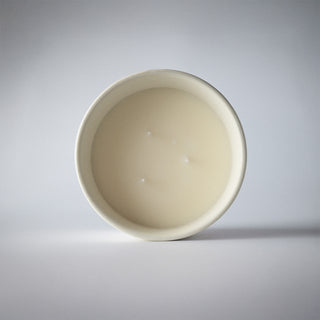 the statement collection candle in the cream ceramic looking at the wax 