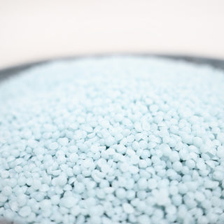 Close-up of light blue wax beads in a bowl