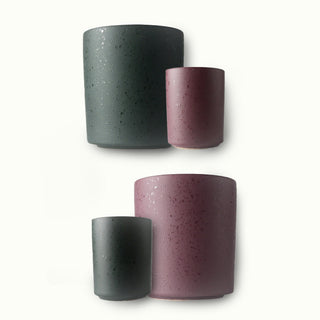 Set of four speckled ceramic pots in green and purple on a white background