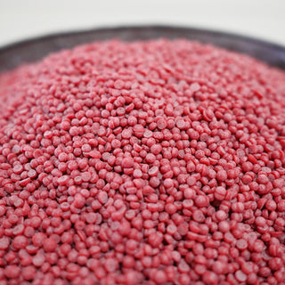 Close-up of red wax beads on a white background