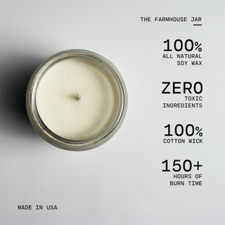 Candle in a glass jar with text highlighting its features on a gray background