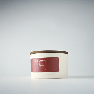 White candle in a tin with a lid on a gray background