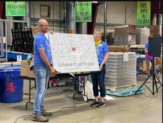 a picture of Janet and Eric holding up their wher is all began sign 