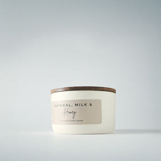 White candle in a tin with a lid on a gray background