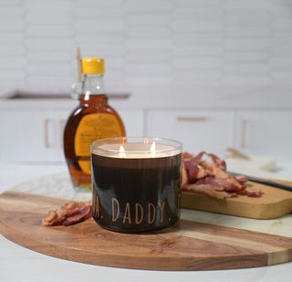 candle next to bacon and syrup
