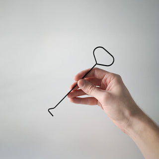 a hand holding the black dipper 
