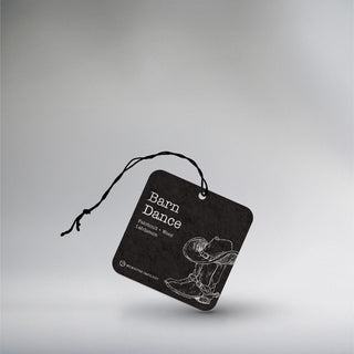 a car freshener with cowboy boots with a cowboy hat hanging of the pair on a blackground 