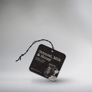 car freshener with a picture of milk with a honey comb on a black background 