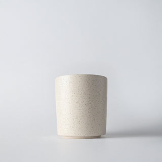 a cream speckled luna lux candle with a white backround 