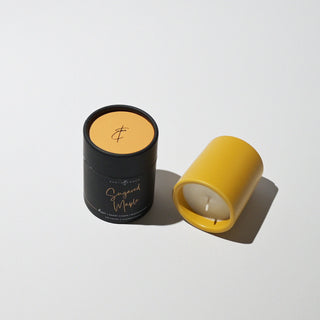 a yellow votive on its side with the tube that it come in 