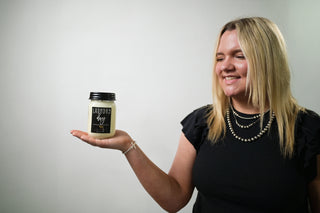 someone holding a 13oz mason jar candle 