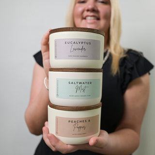 someone holding 3 ceramic statment collection candles 